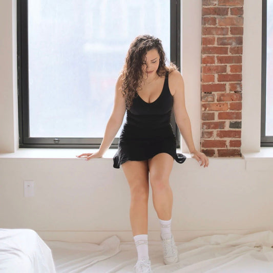 a girl wearing socks sitting behind a window